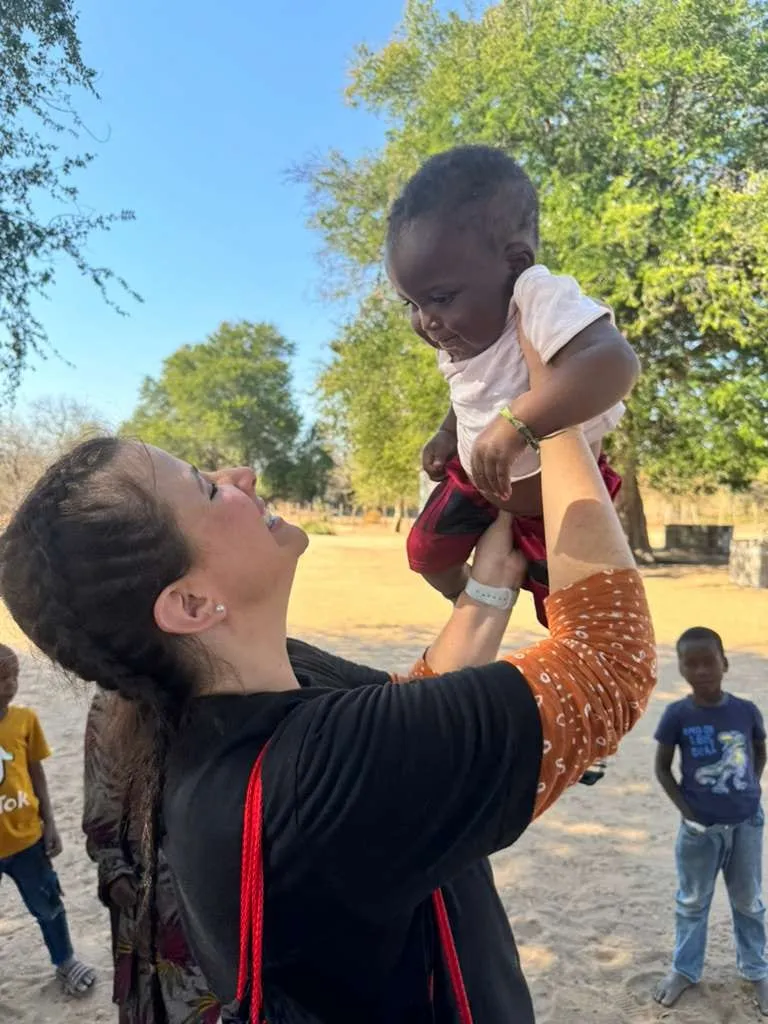 Luísa Marteleto brincando com uma criança ao ar livre