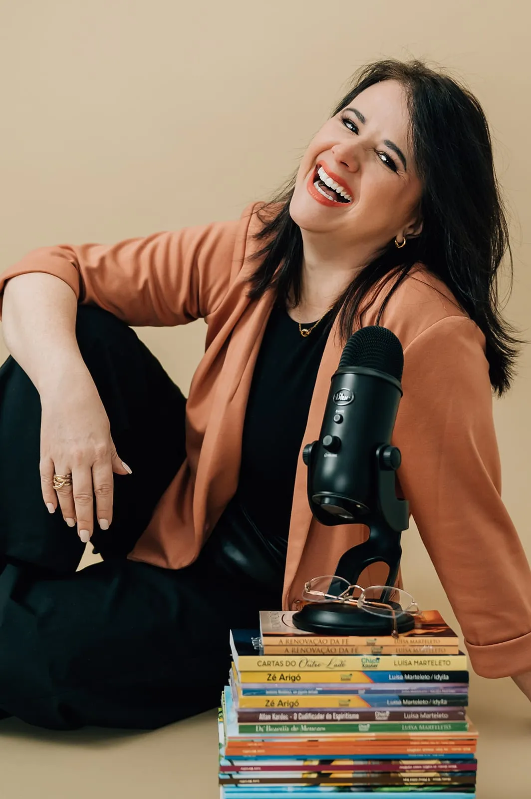 Luísa Marteleto com microfone de mesa e livros