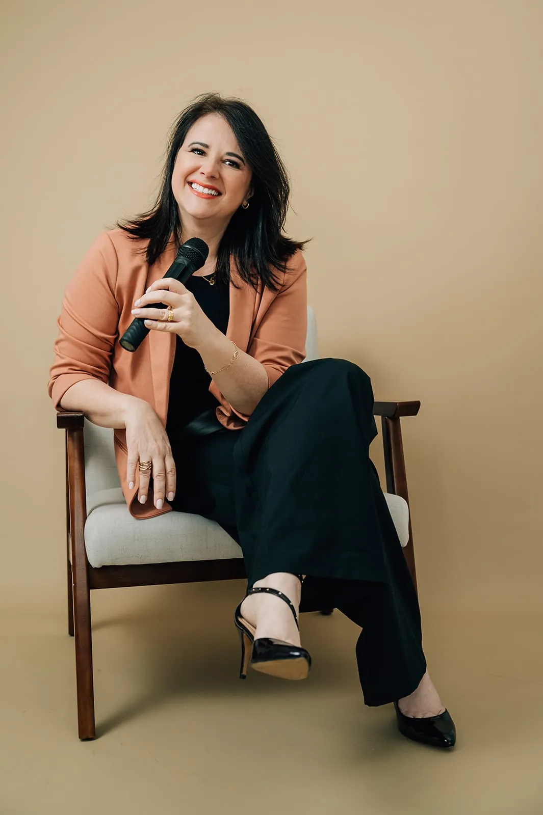 Luísa Marteleto seated with a microphone