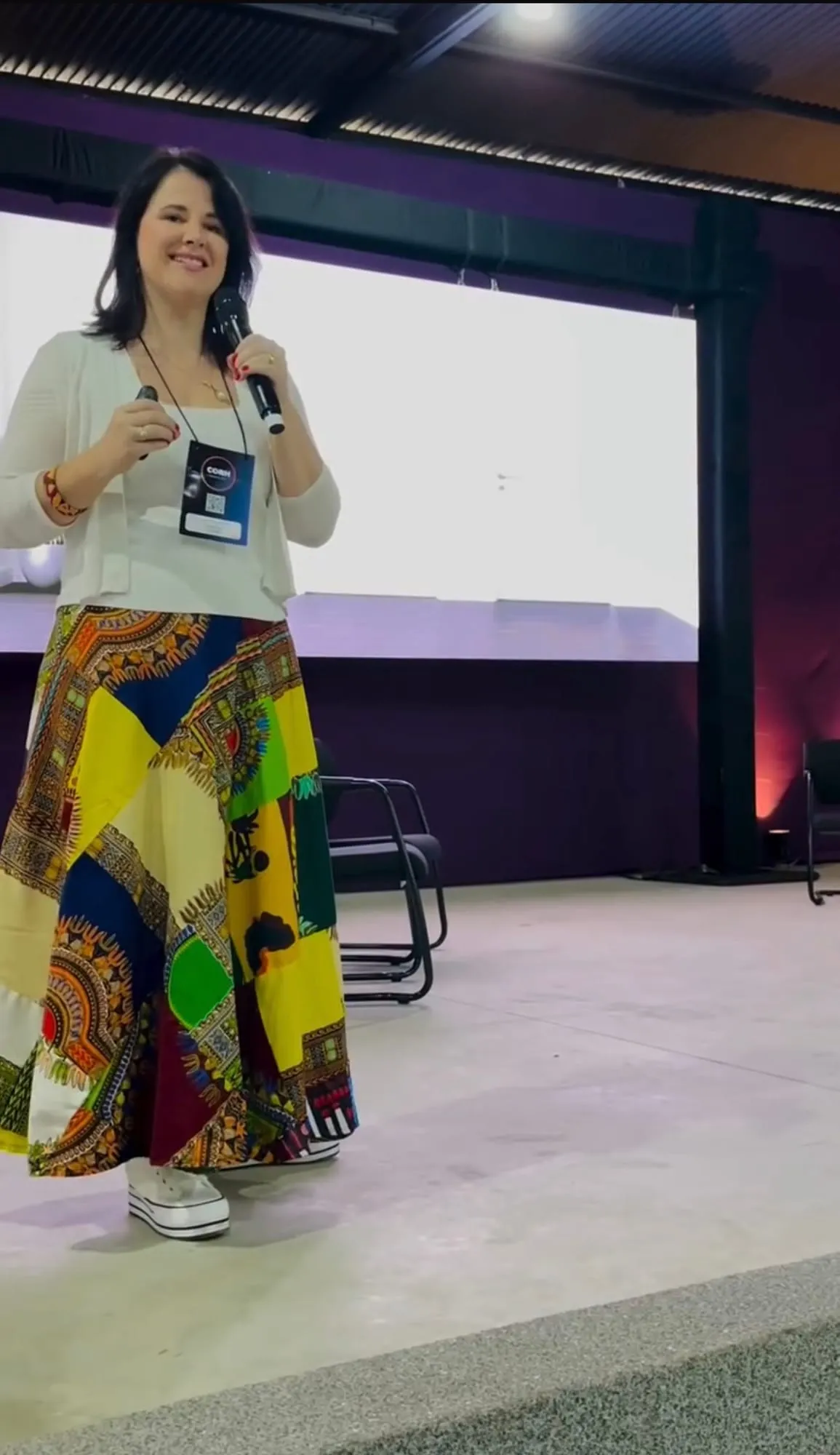 Luísa Marteleto on stage with a microphone